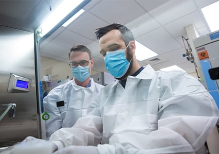 Two fellows setting up a tumor specimen culture.