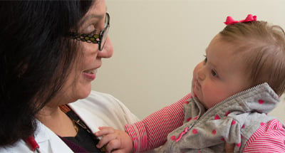 Doctor holding toddler with Down Syndrome