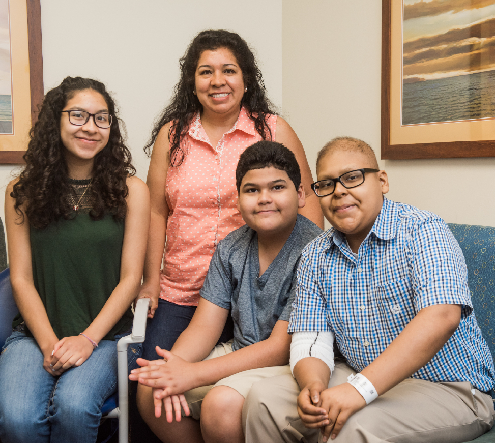 Mica Flatt with family in blue button up shirt with glasses 