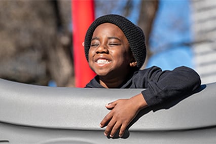 Chase Jackman outside of Children's Mercy with his face turned to the sun. His eyes are close and he is smiling.