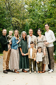 Six adults and three children of the Underdown and Yeomans family smiling outdoors with trees in the background.