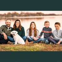 FAB member Josi Wood, her husband, their 3 children and dog sitting on the ground.
