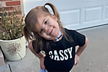 Emersyn Gross posing outside with her hands on her hips, wearing a shirt that says "SASSY."