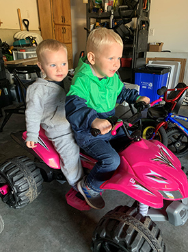 Will and Ben McKinnon on a red ATV (four wheeler).