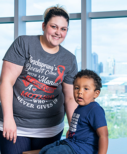 Taitum Ellis with his mother, Ariel. Ariel shirt reads, "Hirschsprung's doesn't come with a manual, it comes with a mother who never gives up."