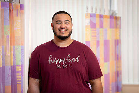 Stuart, Patient Safety Technician, smiling and wearing a shirt that reads, "human kind, be both."