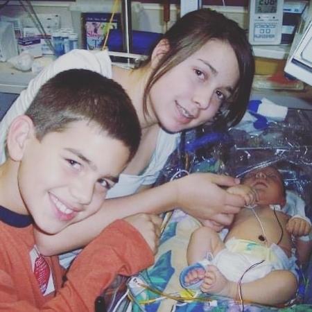 Jaxon with older sister and brother in hospital bed 