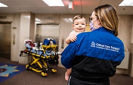 Critical Care Transport team member holding a child at Children's Mercy.