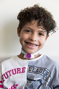 Kieesha Pentlin smiling with a covered trach tube in her neck. She is wearing a shirt that reads, "FUTURE LEADER."