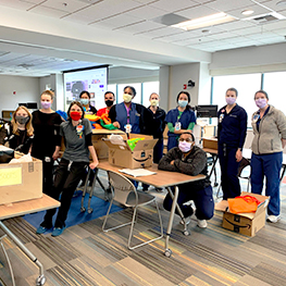 Image of residents in the Children's Mercy Global Health rotation gathered around boxes filled with donated goods.