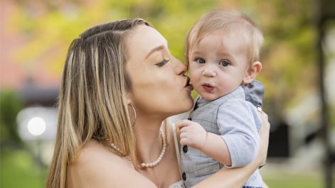 Holden's mother holding him and kissing his cheek