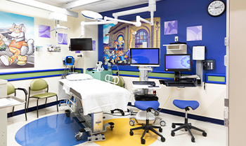 A Uro room at Children's Mercy. There are several chairs, monitors and an examination bed.