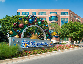 Photo of Children's Mercy Kansas City with a  sign that reads, "Children's Mercy Adele Hall Campus."