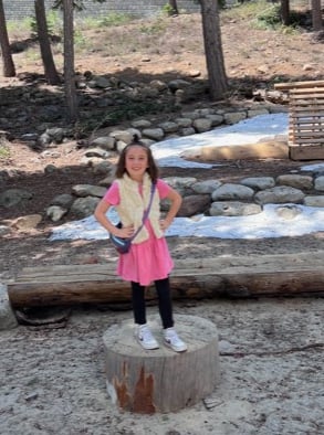 ella standing on tree trunk 