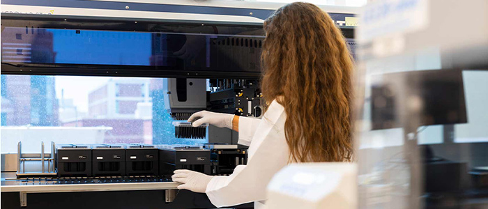 Image of a researcher in the Genomic Medicine Center working on genetic sequencing.