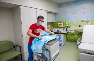 A Children's Mercy nurse uncovering a cart with medical supplies.