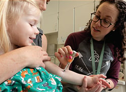 A J-Tip being used to apply numbing medication on a child's arm.