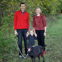 Andrew Carr with his wife, their son and their dog.