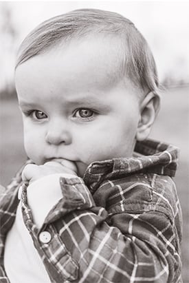 Black and white photo of Will Mckinnon wearing a plaid shirt.