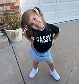 Emersyn Gross posing outside with her hands on her hips, wearing a shirt that says "SASSY."
