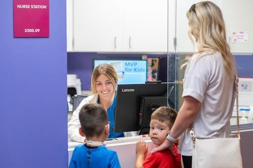 patient, sibling, and mother checking in at front desk 