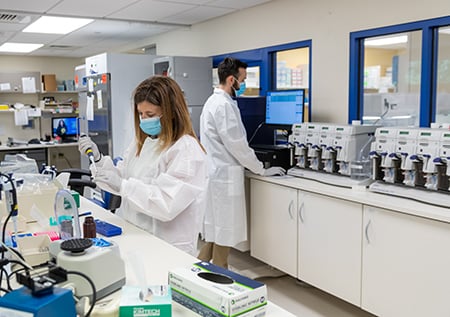 Two fellows washing and scanning microarray.