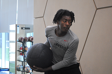 Deron throws the medicine ball against a wall to increase his explosiveness. 