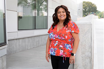 Sylvia Hernandez is smiling and standing outside of the Children's Mercy Research Institute.