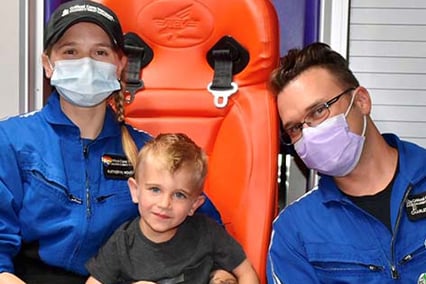 Owen Sheeley with transport team members posing in front of Children's Mercy ambulance.