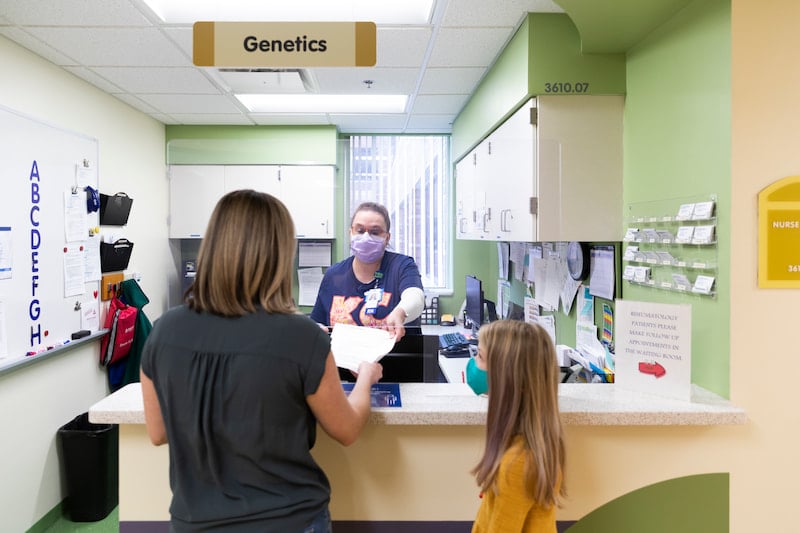 A female nurse shares a care plan with a family at the Children's Mercy Genetics Clinic.