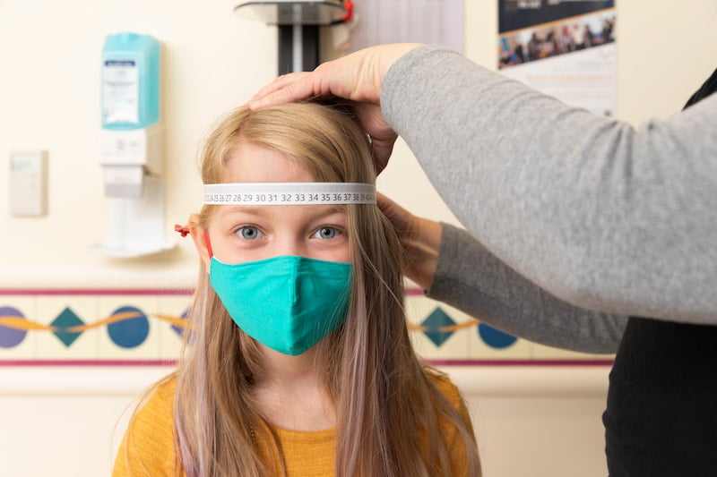 A female patient has her head circumference measured by a Children's Mercy nurse.