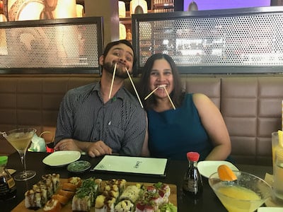 Two members of the Children's Mercy Child Neurology Residency pose with chopsticks in their mouths.