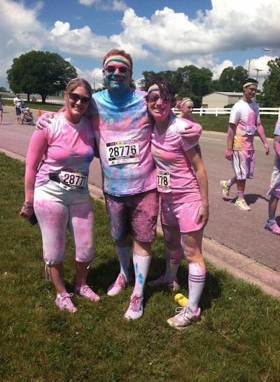 Three members of the Children's Mercy Child Neurology Residency team pose with colorful chalk on their bodies after a race.