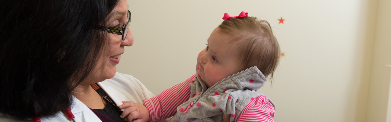 Doctor holding toddler with Down Syndrome
