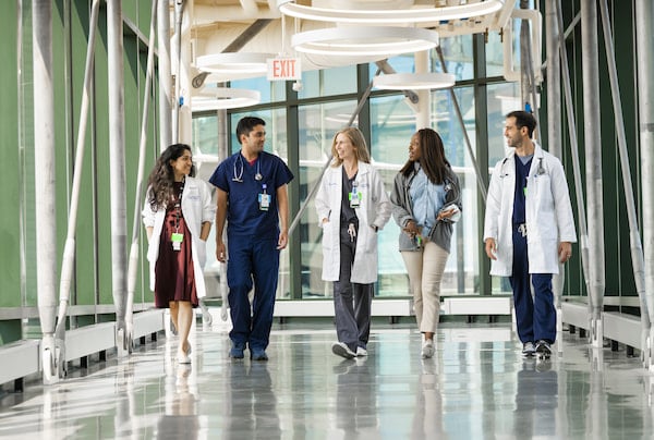 Five Children's Mercy Pediatric Cardiology fellows walk together in the hallway of the Children's Mercy Research Institute.