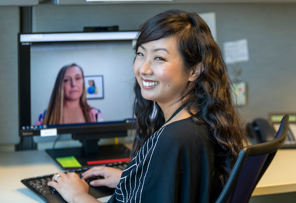 A female medical professional interacts with another female via video chat.