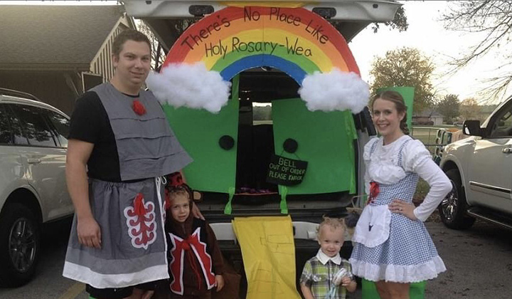 Emily Mccarty, husband and two sons stand at their decorated trunk or treat as Wizard of Oz characters for Halloween.