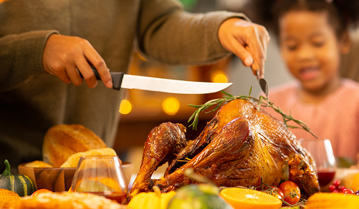 Mom carving a turkey at a meal