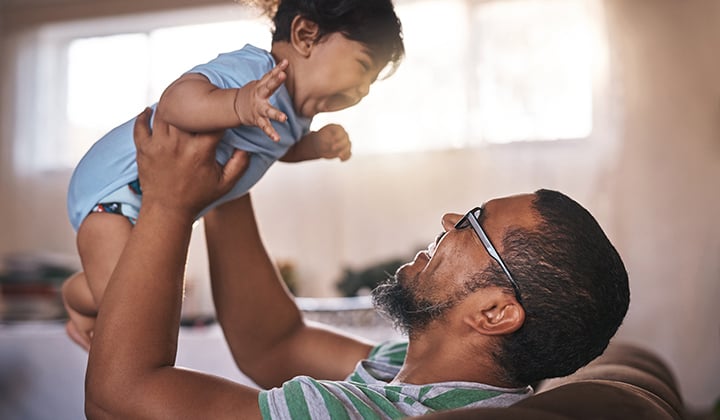 Dad holding up baby