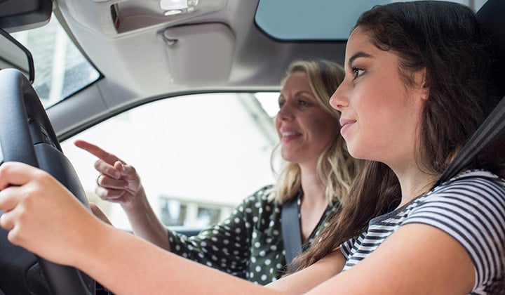 Mom teaching teenage daughter how to drive