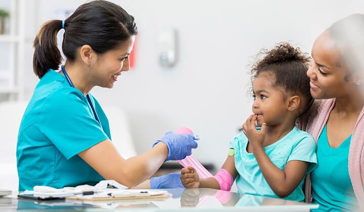 nurse helps young girl with hurt arm