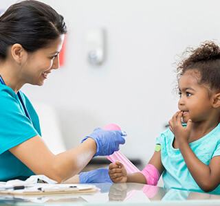 nurse helps young girl with hurt arm