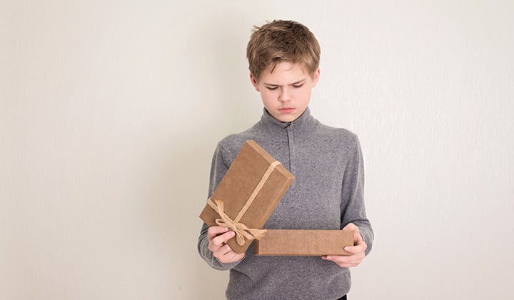 Kid opening present box and frowning