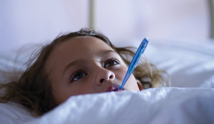 Girl in bed with thermometer