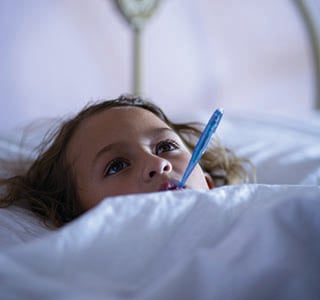 Girl in bed with thermometer