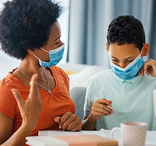 Mom showing son how to wear a face mask