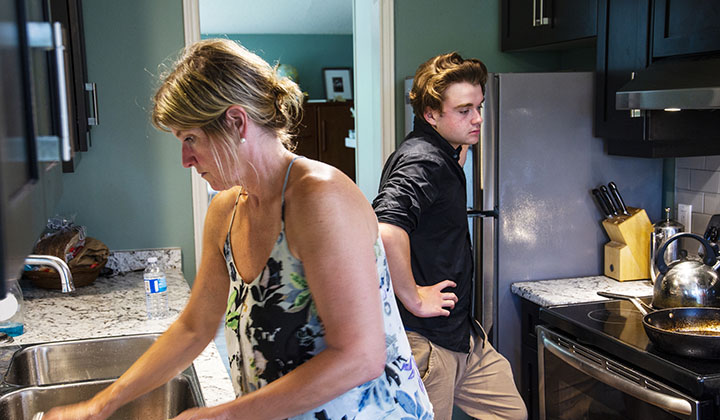 Teen and mom in kitchen cleaning