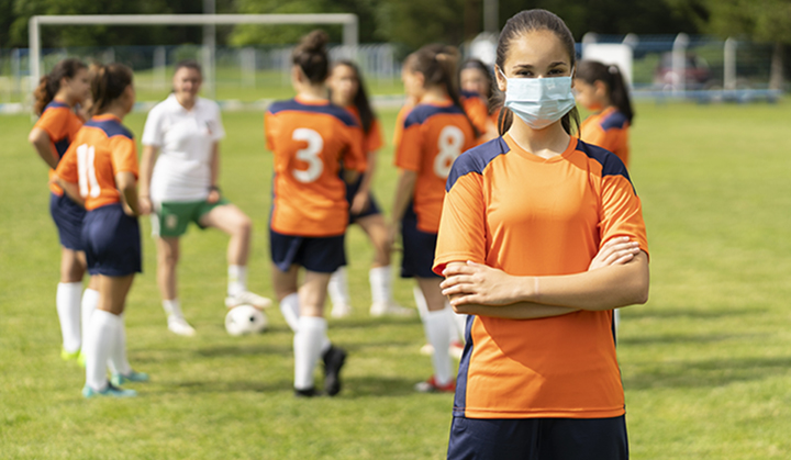 soccer player female wearing a face mask arms crossed