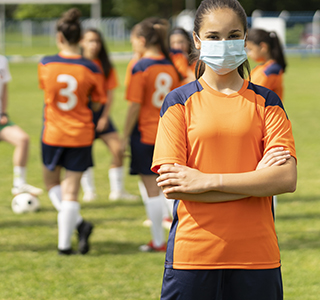 soccer player female wearing a face mask arms crossed