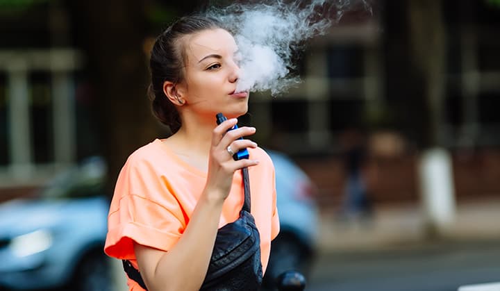 Young girl vaping outside